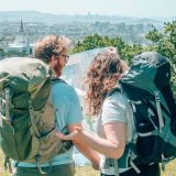 Deux voyageurs avec sacs à dos prêts pour l'aventure, paysage de voyage en arrière-plan