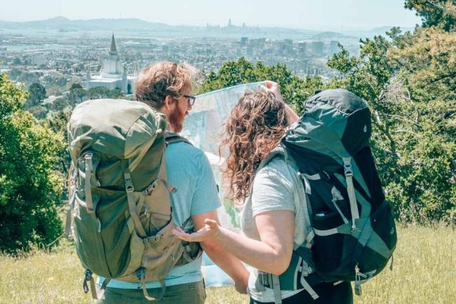 Deux voyageurs avec sacs à dos prêts pour l'aventure, paysage de voyage en arrière-plan