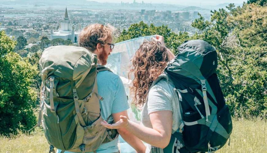 Deux voyageurs avec sacs à dos prêts pour l'aventure, paysage de voyage en arrière-plan